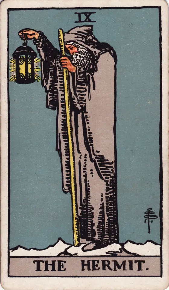 The Hermit from the 1909 deck: an old man in a grey cloak on a snowy height holds up a lantern with a star in it.